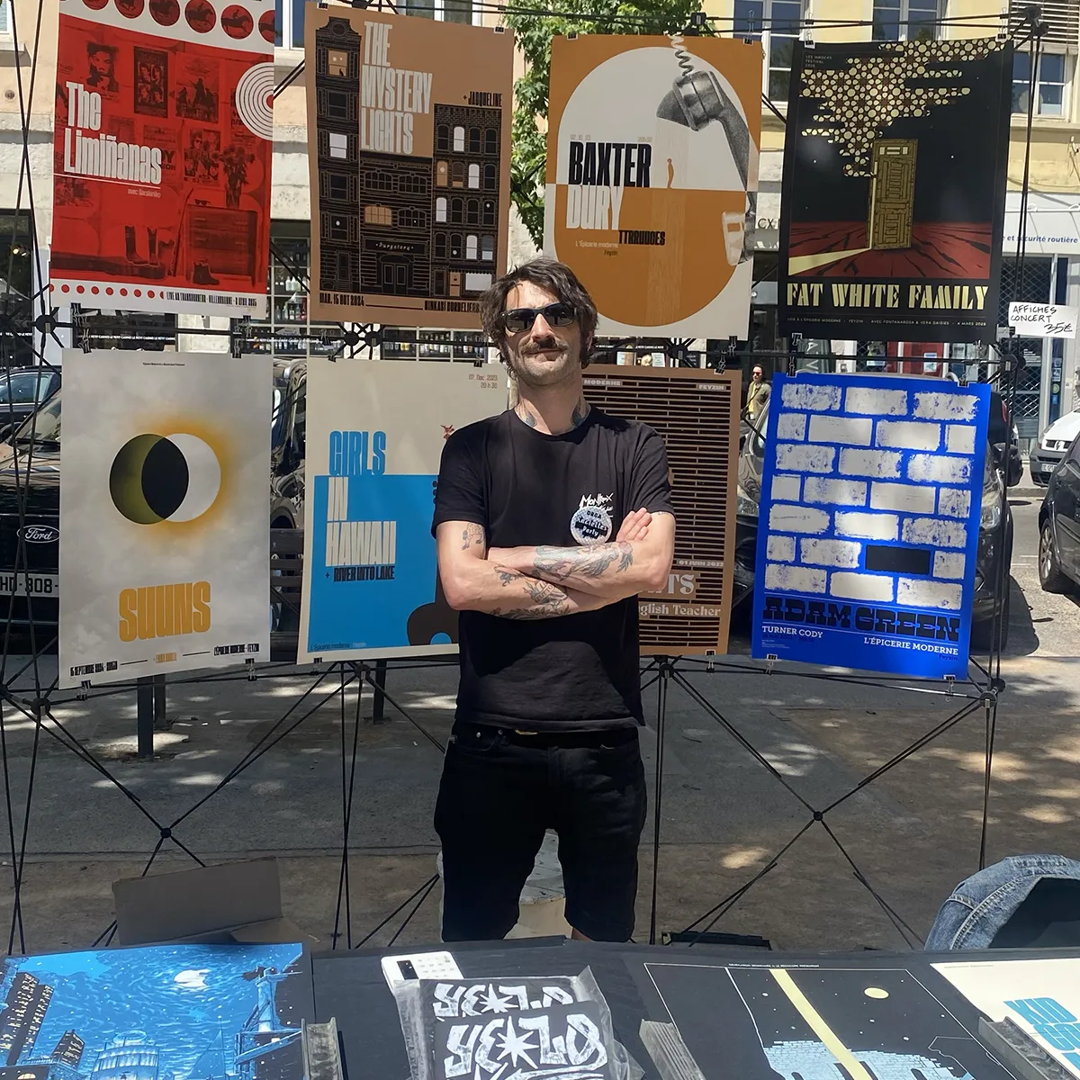 Photo de Joël Blanc-Tailleur / Sacrés Caractères derrière son stand lors d'un salon de micro-édition.